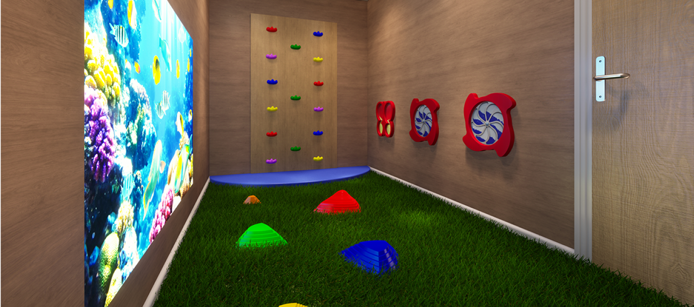 Sensory room with fake grass and coloured blocks on the wall